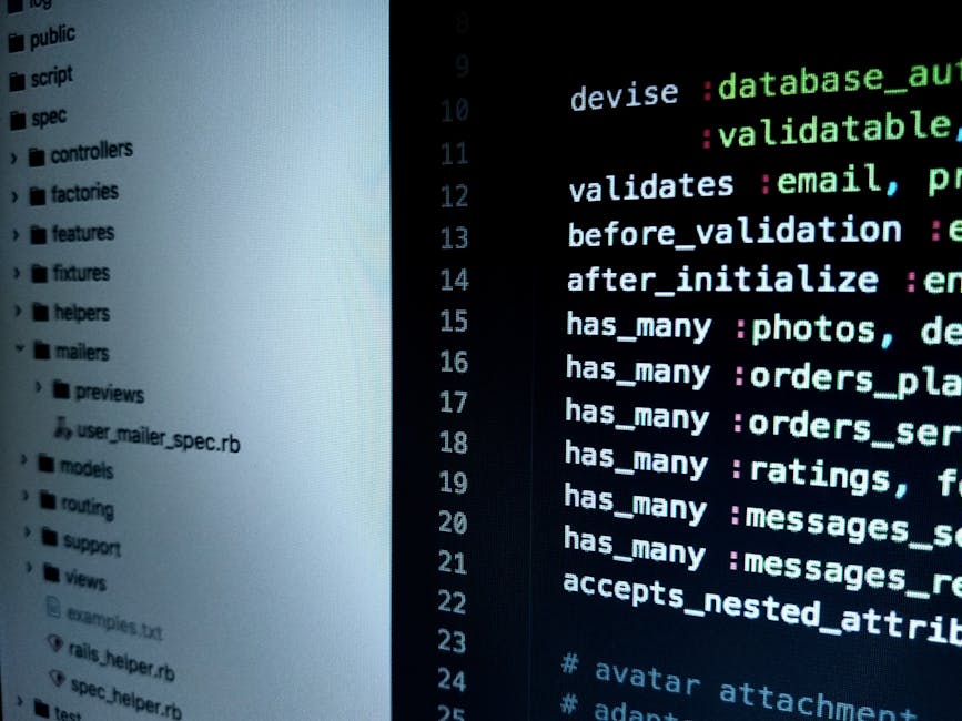 A person working on a laptop with a black screen displaying lines of colorful code in green, blue, and white, situated on a dark table. The individual's hands are visible, with the right hand poised o